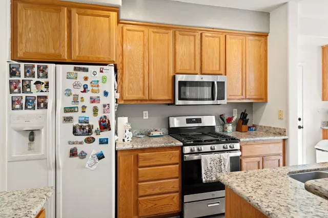 a kitchen with stainless steel appliances a stove a microwave and a window