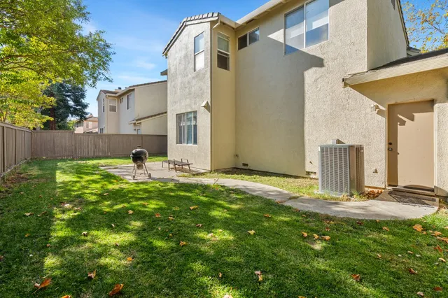 a backyard of a house with table and chairs