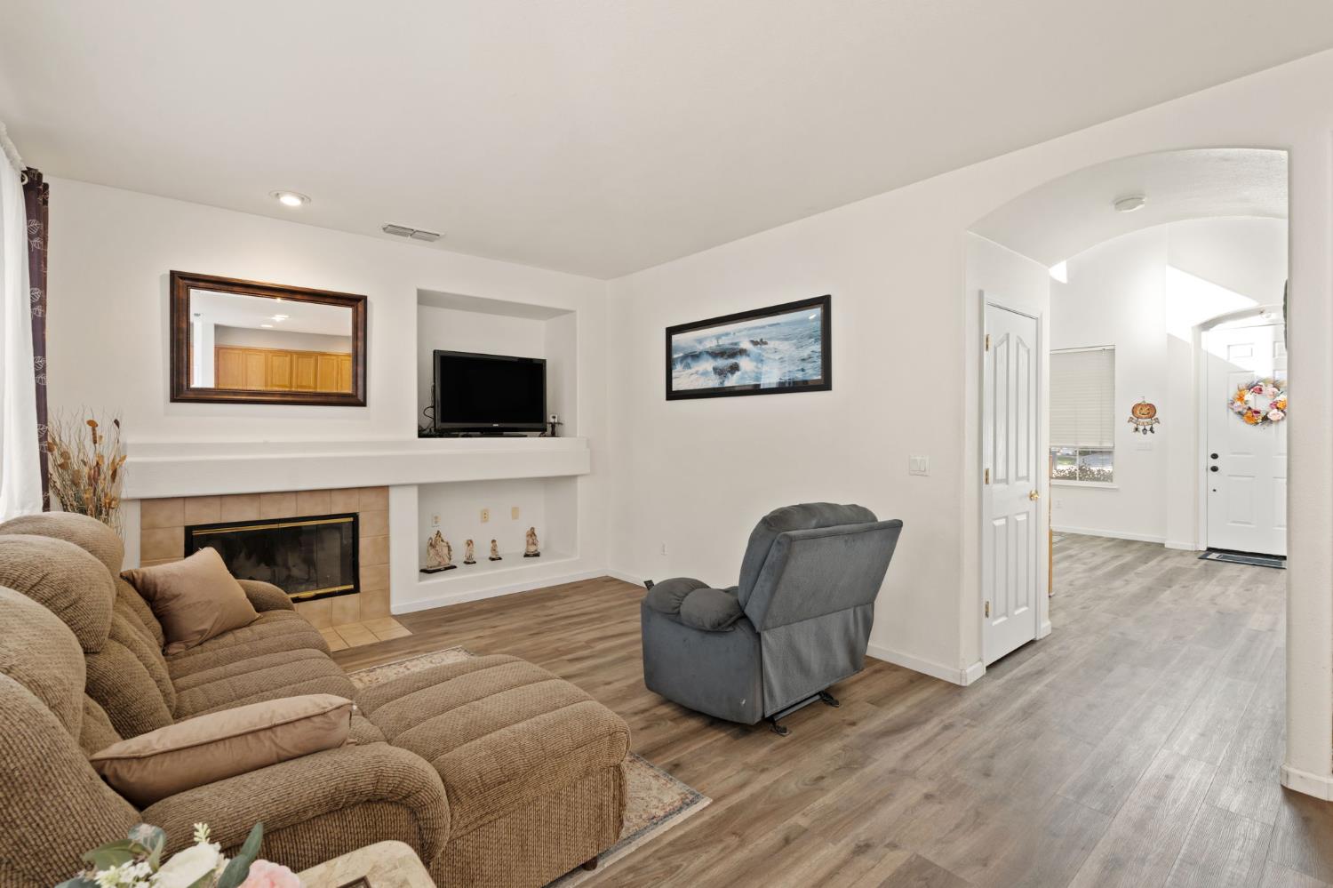 46 Bascom Court Sacramento, CA 95835 - Photo 8 of 34 a living room with furniture a flat screen tv and a fireplace