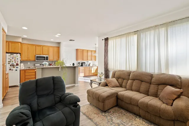 a living room with furniture kitchen view and a window