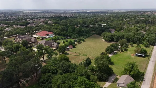 an aerial view of lake residential house with outdoor space and trees all around
