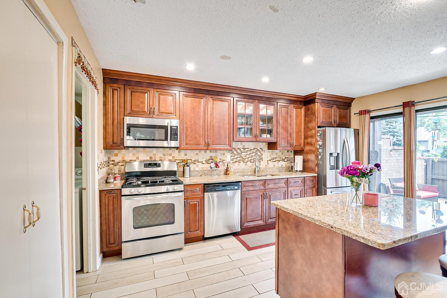 564 Westgate Drive Edison, NJ 08820 - Photo 11 of 37 a kitchen with stainless steel appliances granite countertop a stove a sink dishwasher and a refrigerator