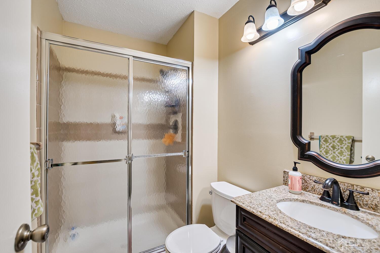 564 Westgate Drive Edison, NJ 08820 - Photo 22 of 37 a bathroom with a granite countertop sink toilet mirror and shower