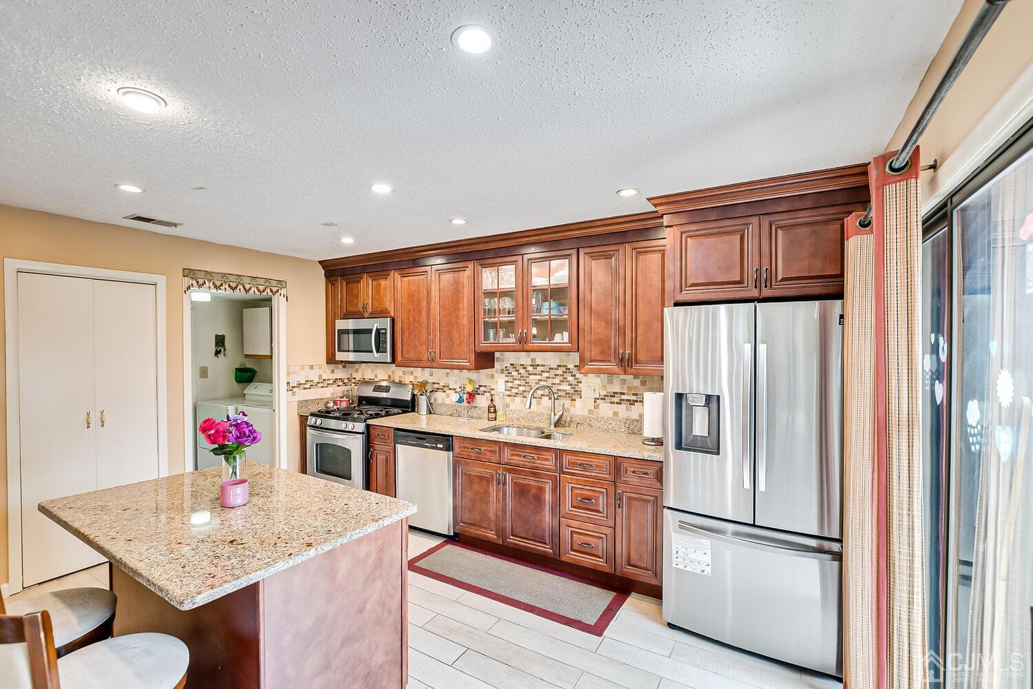 564 Westgate Drive Edison, NJ 08820 - Photo 8 of 37 a kitchen with stainless steel appliances granite countertop a refrigerator and a stove top oven