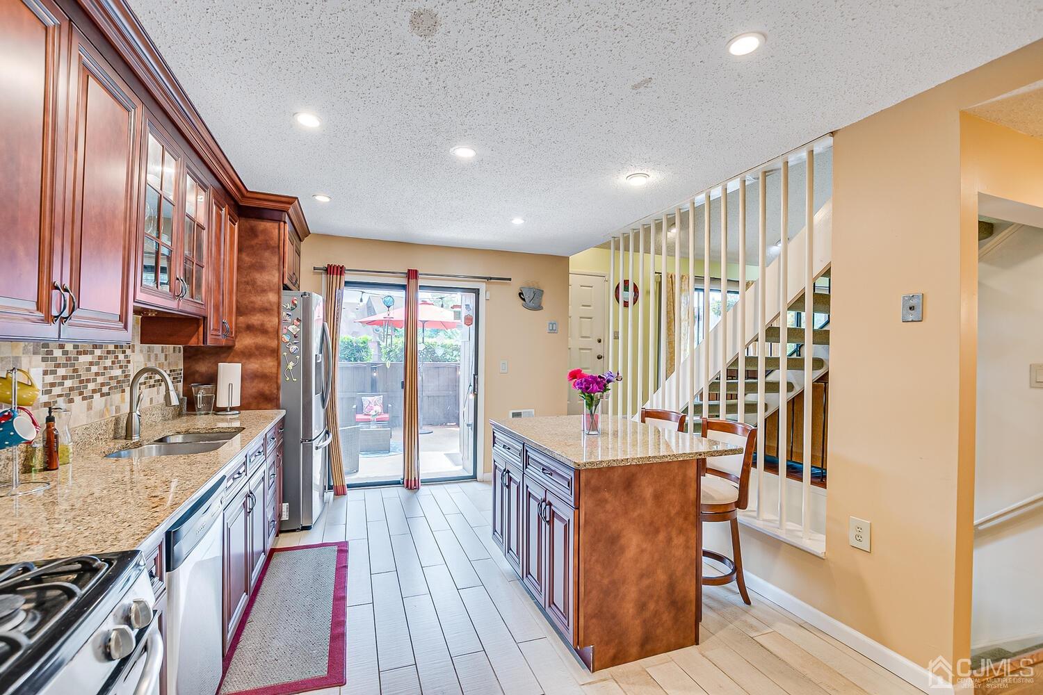 564 Westgate Drive Edison, NJ 08820 - Photo 9 of 37 a hallway with wooden floor and staircase