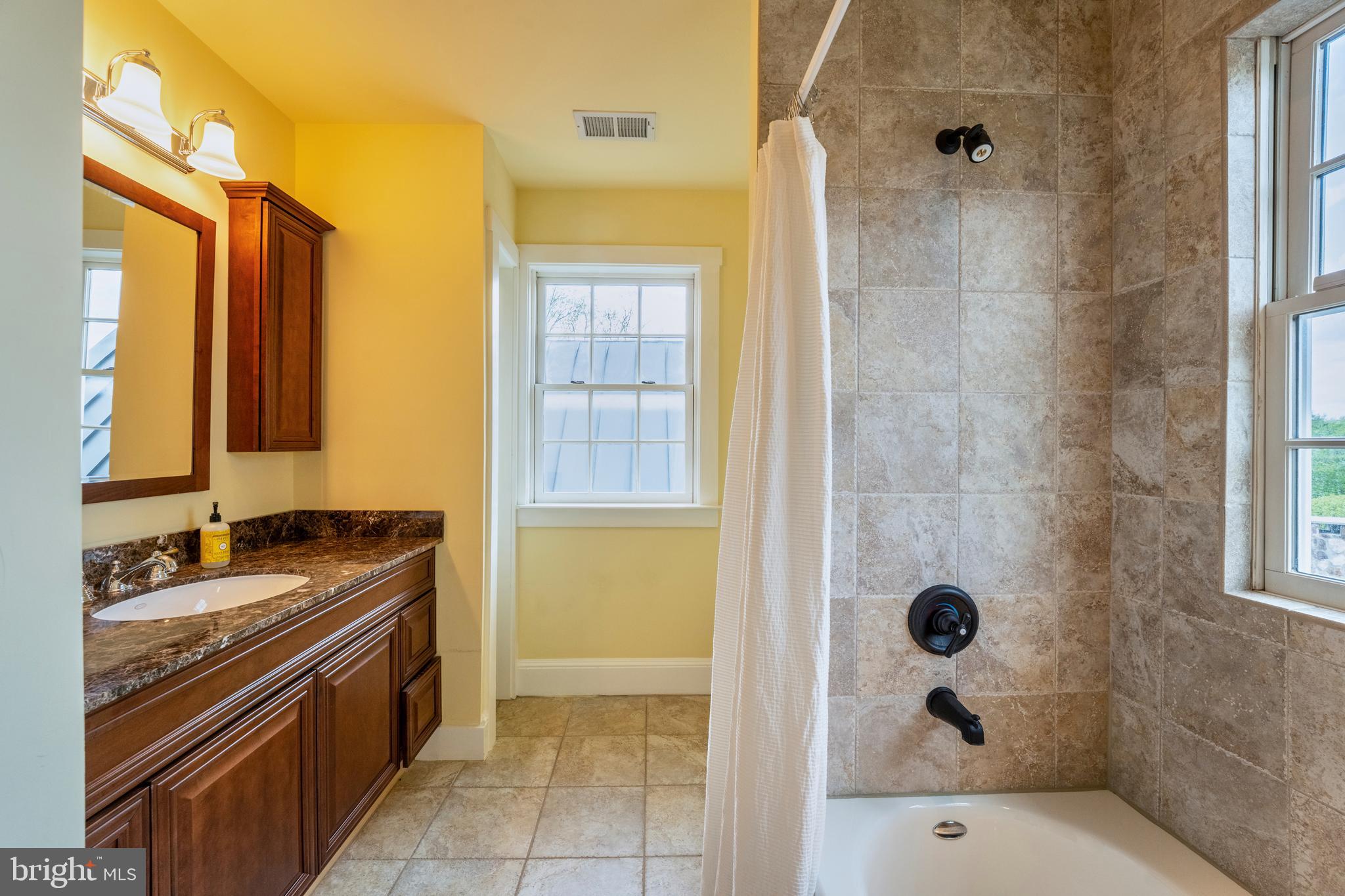 15718 Old Waterford Road Waterford, VA 20197 - Photo 43 of 81 a bathroom with a granite countertop sink a mirror and a bathtub