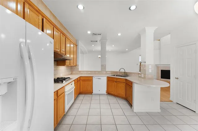 a large kitchen with stainless steel appliances lots of white cabinets