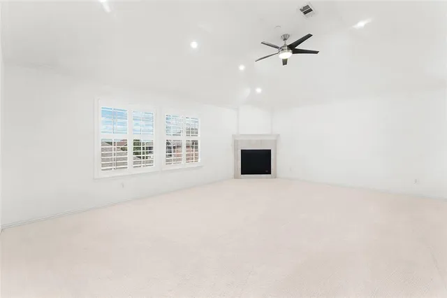 a view of an empty room with a fireplace and a window