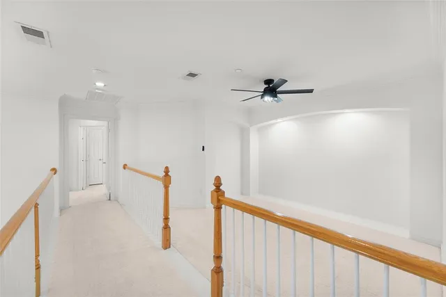 a view of a hallway with a ceiling fan