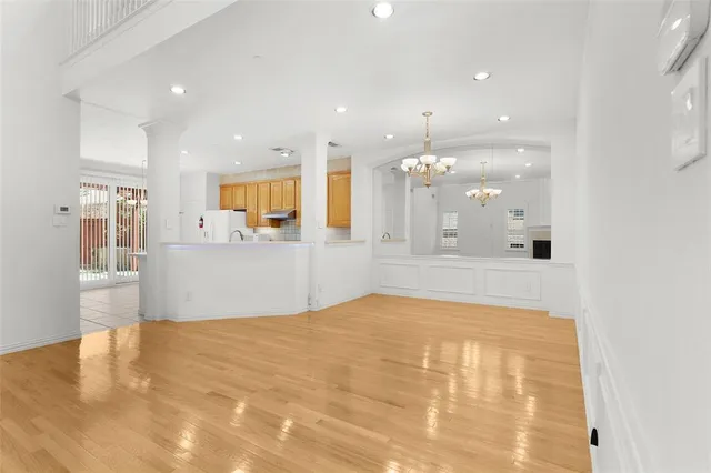 a view of a kitchen with kitchen island white cabinets and wooden floor