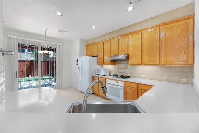 a kitchen with stainless steel appliances granite countertop a sink refrigerator and cabinets
