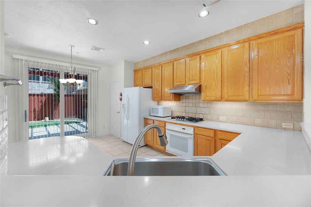 8108 Locust Street Irving, TX 75063 - Photo 8 of 39 a kitchen with stainless steel appliances granite countertop a sink refrigerator and cabinets