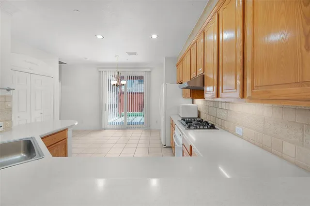 a kitchen with granite countertop a sink and a stove top oven