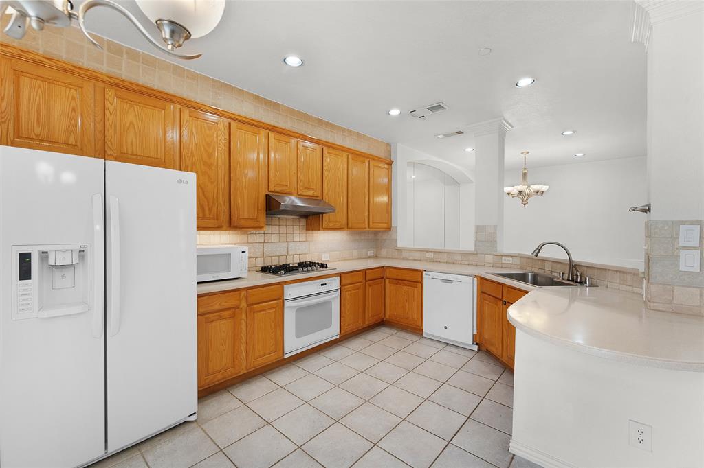 8108 Locust Street Irving, TX 75063 - Photo 10 of 39 a kitchen with stainless steel appliances granite countertop a sink stove and refrigerator
