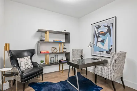 a living room with furniture and a painting on the wall