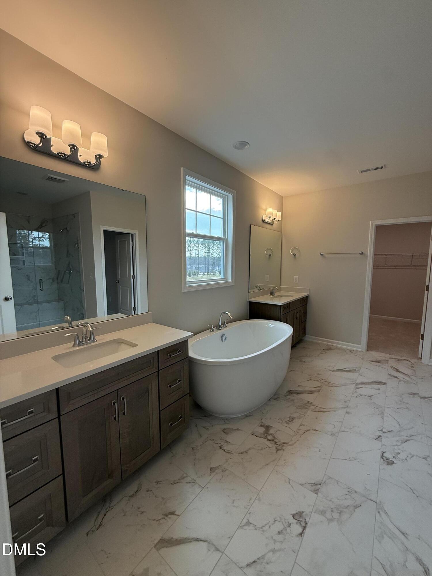 2437 Picual Way Apex, NC 27502 - Photo 15 of 31 a spacious bathroom with a bathtub sink and mirror
