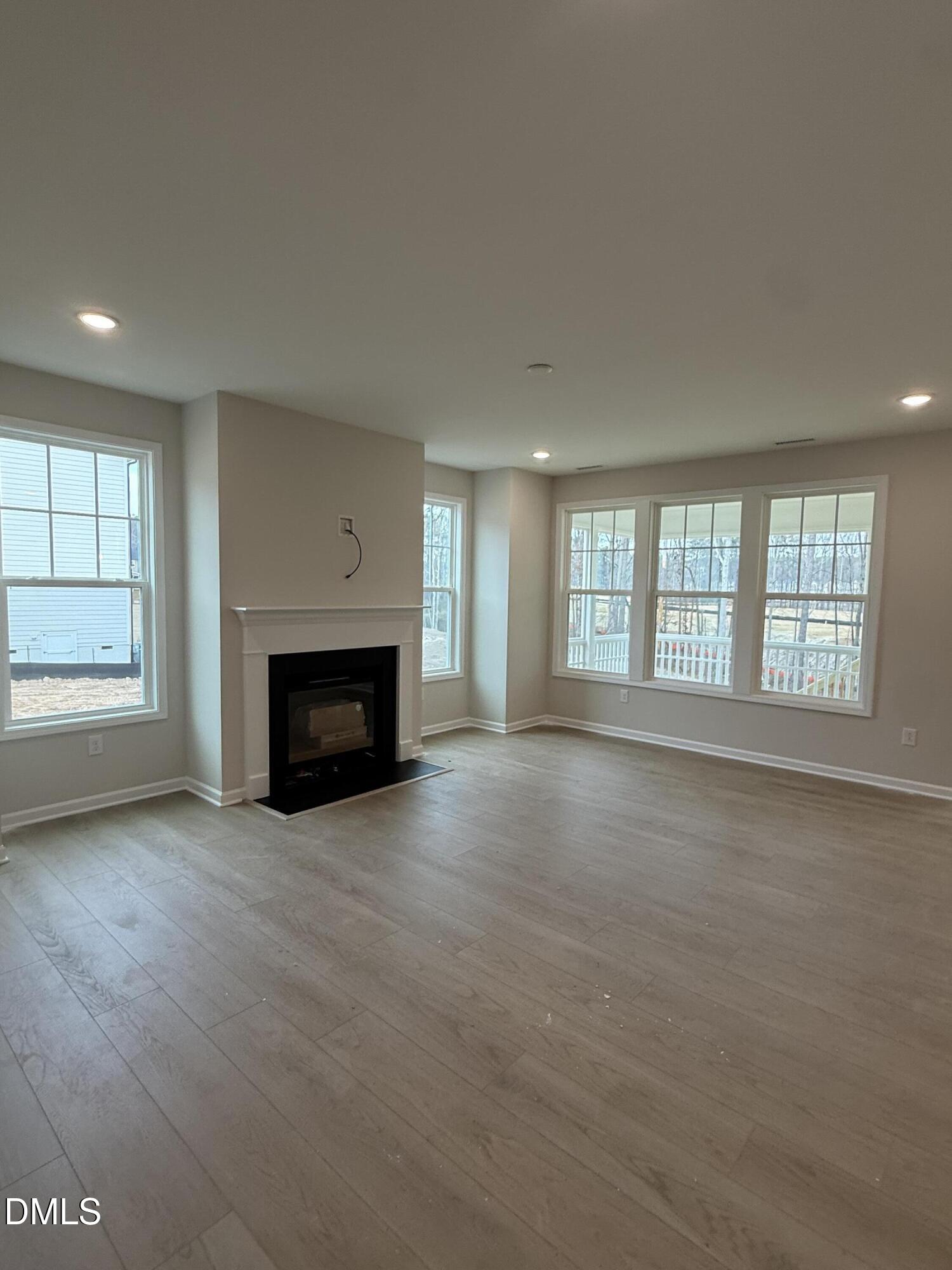 2437 Picual Way Apex, NC 27502 - Photo 5 of 31 an empty room with windows and fireplace