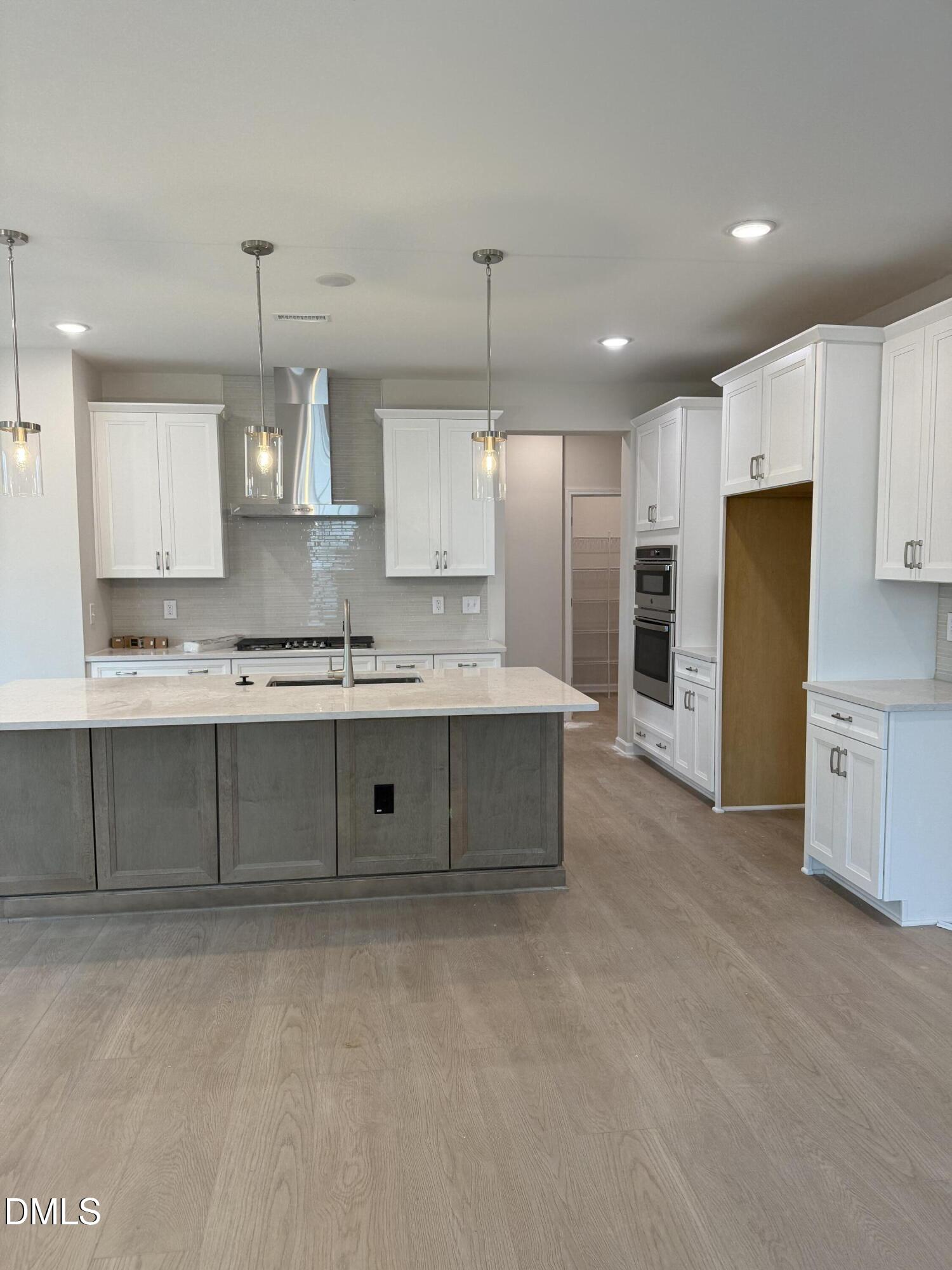 2437 Picual Way Apex, NC 27502 - Photo 6 of 31 a large kitchen with cabinets stainless steel appliances and a counter top