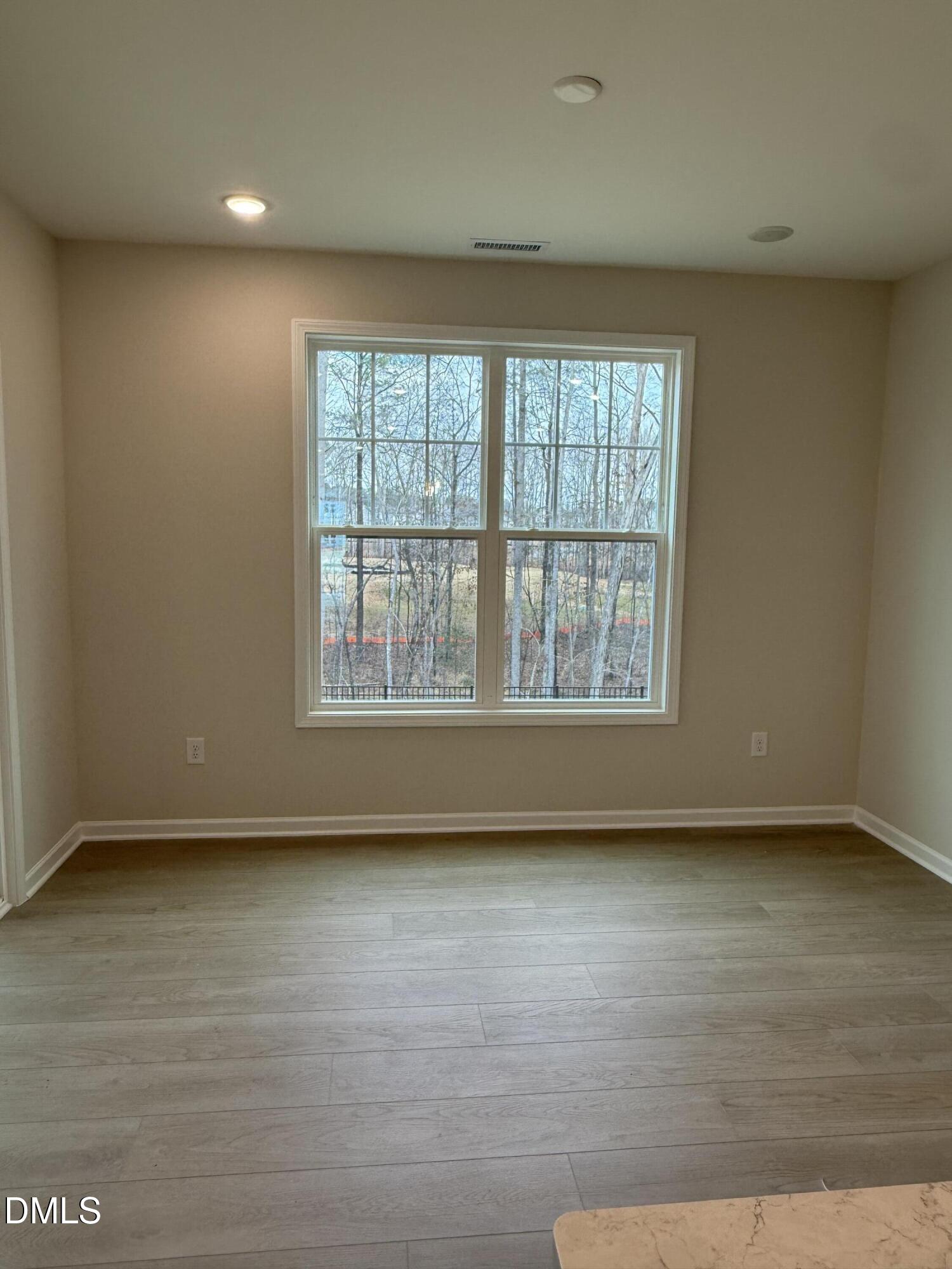 2437 Picual Way Apex, NC 27502 - Photo 7 of 31 wooden floor in an empty room with a window