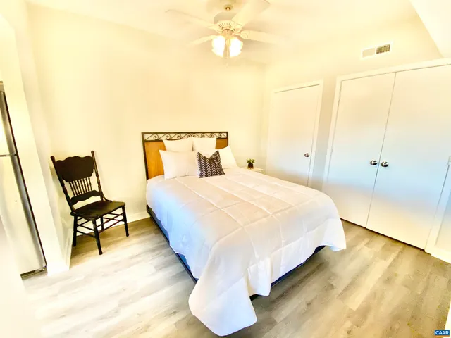 a spacious bedroom with a bed and wooden floor