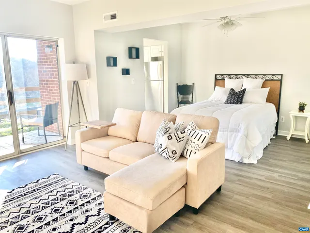 a bedroom with a bed lamp and a large window