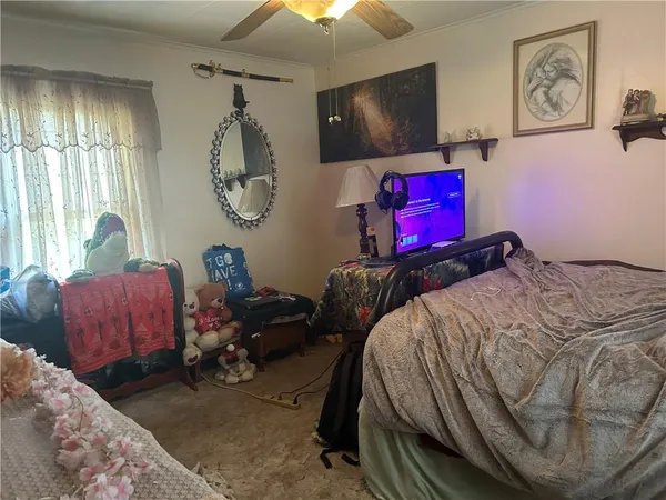 a bedroom with bed and a flat tv screen on dresser