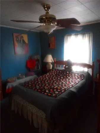 a bed sitting in a bedroom next to a window and a chandelier