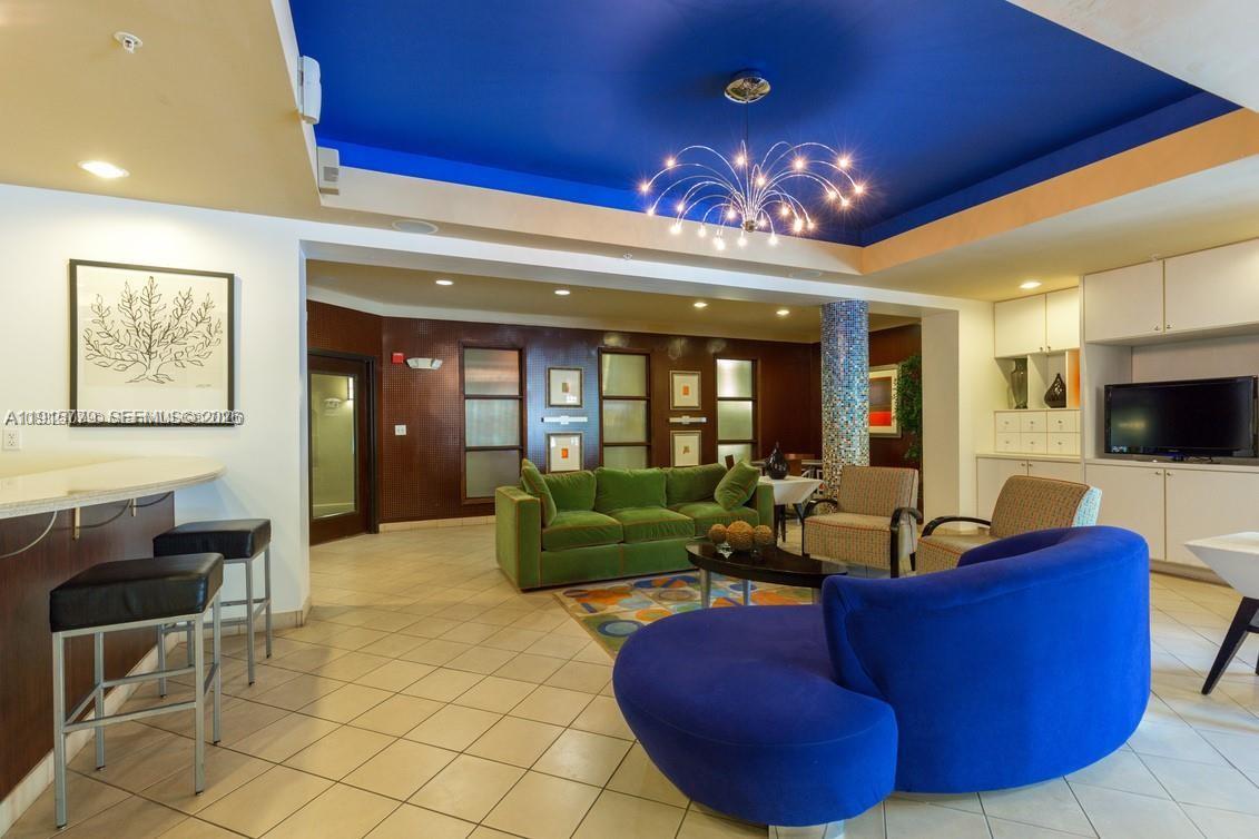 6001 Southwest 70th Street, Unit 115 South Miami, FL 33143 - Photo 3 of 16 a living room with furniture and a large mirror