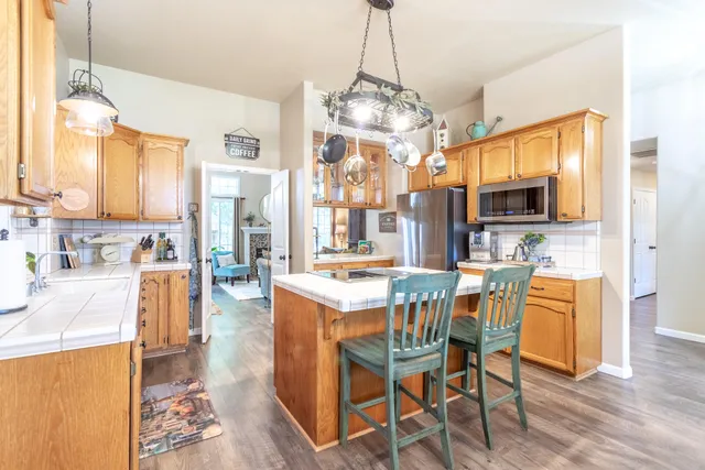 a view of a dining room and livingroom with furniture wooden floor a chandelier