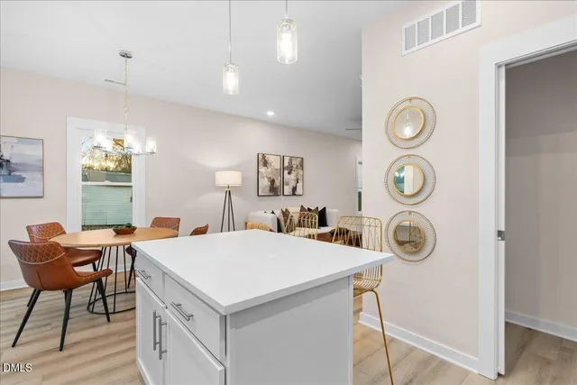 a view of a kitchen area with furniture and stainless steel appliances