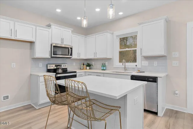 a kitchen with granite countertop a stove top oven a sink dishwasher and a refrigerator with wooden floor