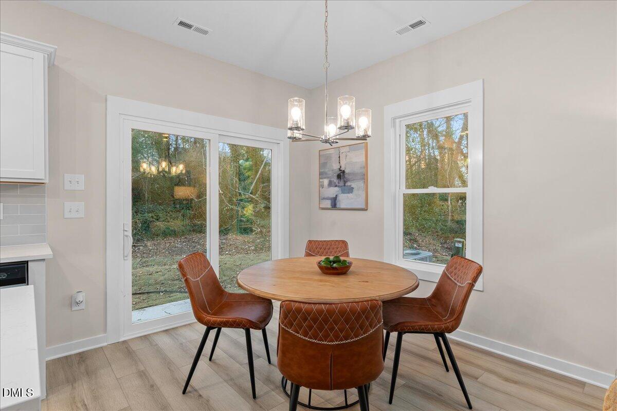 1917 Essex Road, Unit A Durham, NC 27704 - Photo 9 of 26 a dining room with furniture a chandelier and wooden floor
