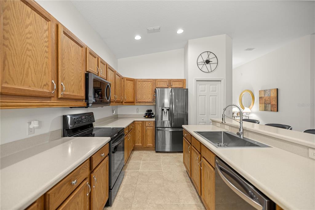 1636 West Caroline Path Lecanto, FL 34461 - Photo 41 of 85 a kitchen with stainless steel appliances a sink stove refrigerator and cabinets