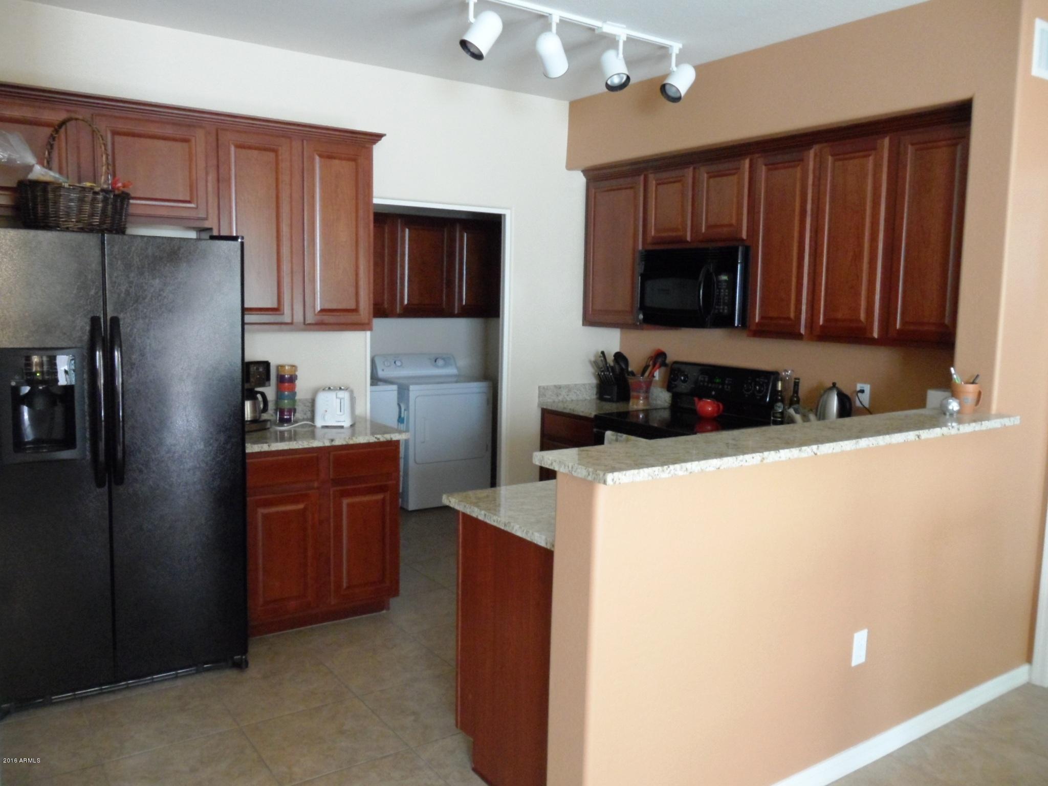 3330 South Gilbert Road, Unit 1015 Chandler, AZ 85286 - Photo 4 of 30 a kitchen with stainless steel appliances granite countertop a refrigerator stove top oven a sink and dishwasher