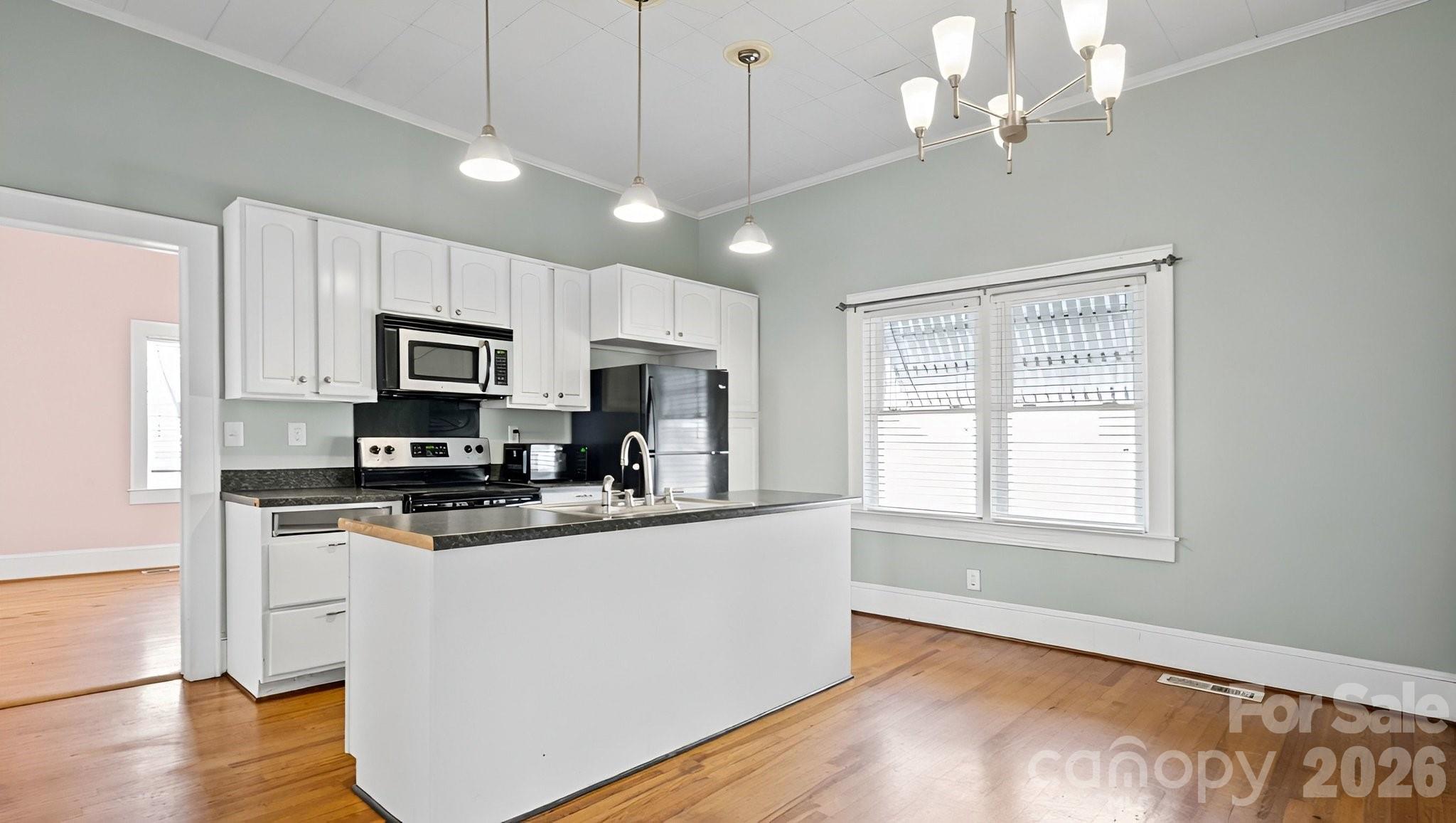 901 Mill Street Albemarle, NC 28001 - Photo 11 of 27 a kitchen with kitchen island granite countertop a stove a sink a center island and wooden floor