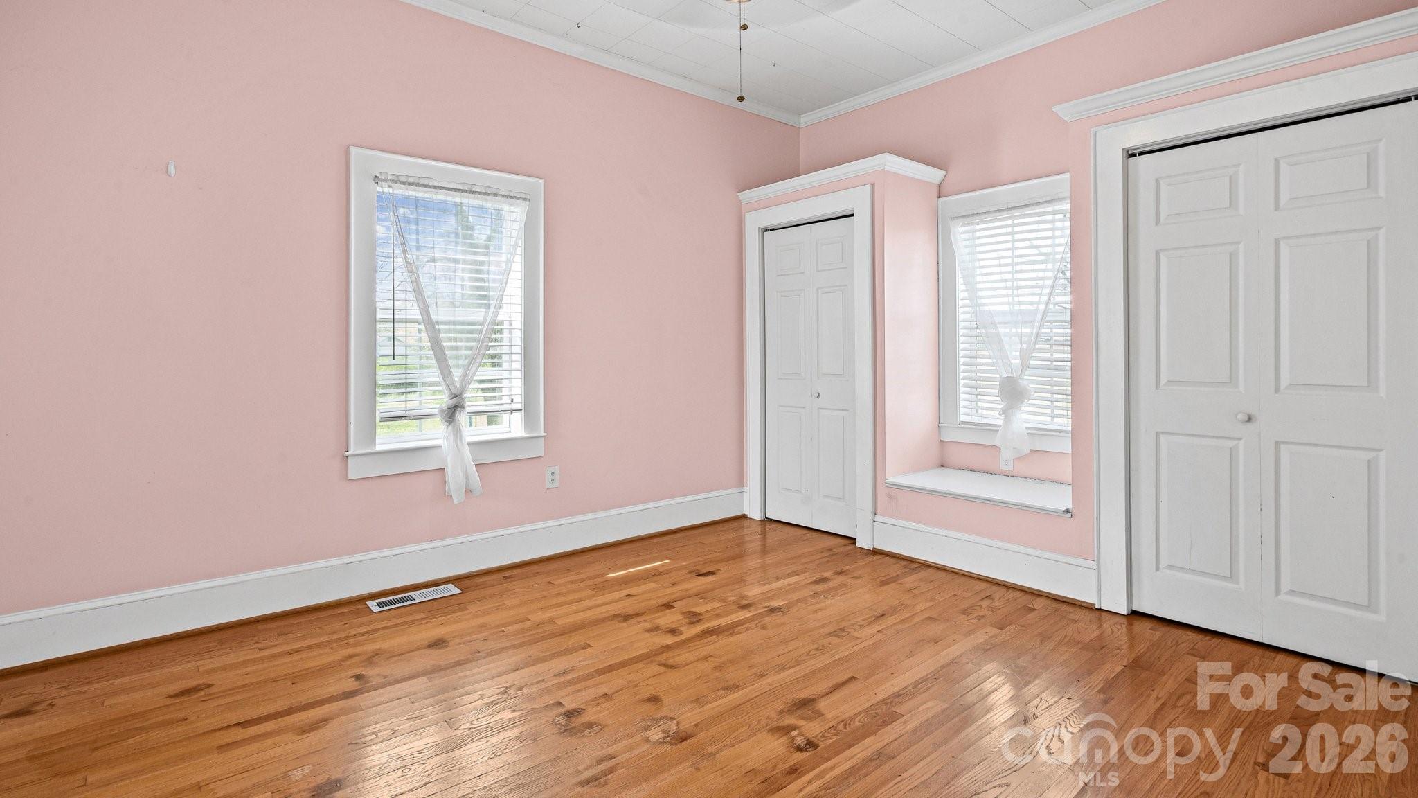 901 Mill Street Albemarle, NC 28001 - Photo 19 of 27 an empty room with wooden floor and windows