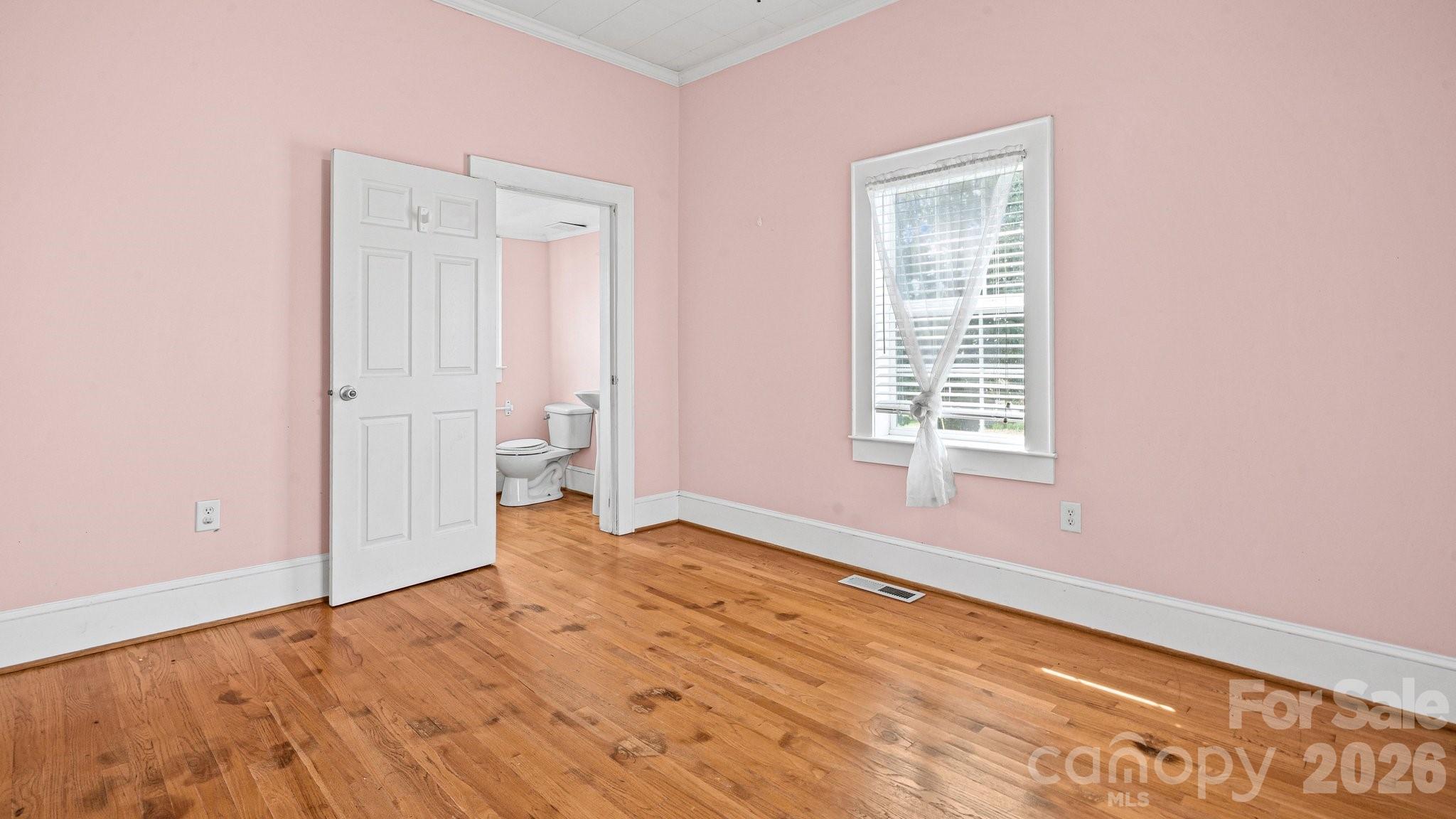901 Mill Street Albemarle, NC 28001 - Photo 20 of 27 an empty room with wooden floor and windows