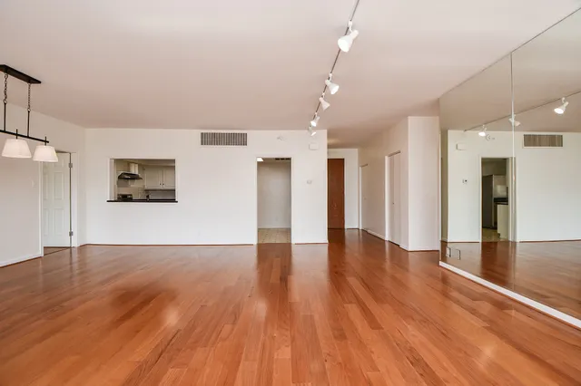 a view of a room with wooden floor and a kitchen