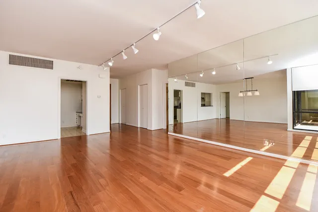 a view of an empty room with wooden floor