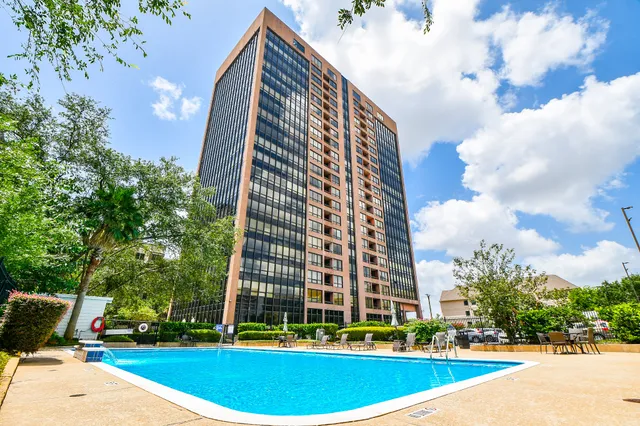 a view of a tall building next to a yard