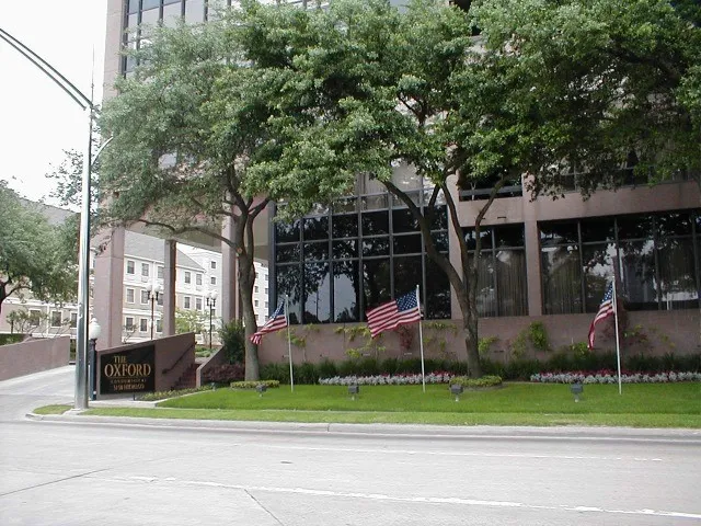 a front view of a house with a garden and trees