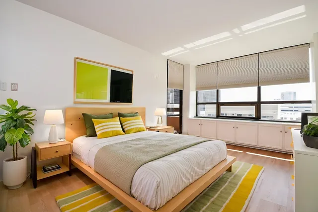 a bedroom with a bed and a potted plant