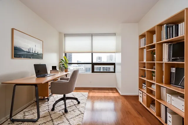a view of a workspace with furniture and a bookshelf