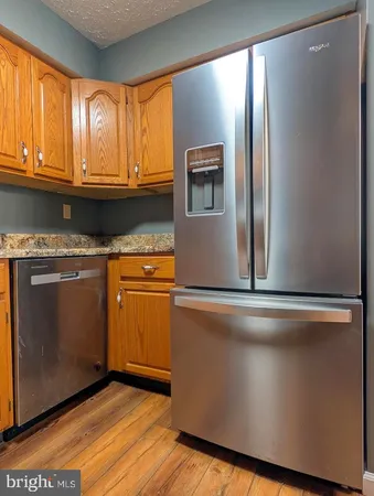 a kitchen with granite countertop cabinets stainless steel appliances and a large window