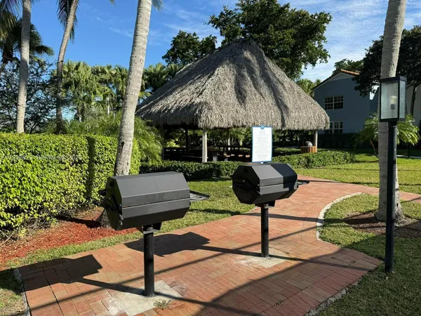 a view of a table and chairs under an umbrella in the yard