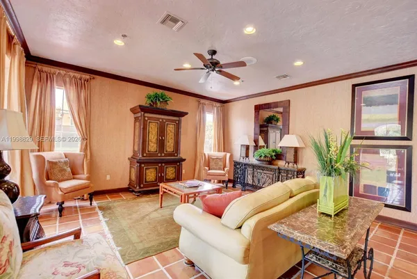 a living room with furniture ceiling fan and a window