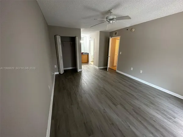 an empty room with wooden floor and closet