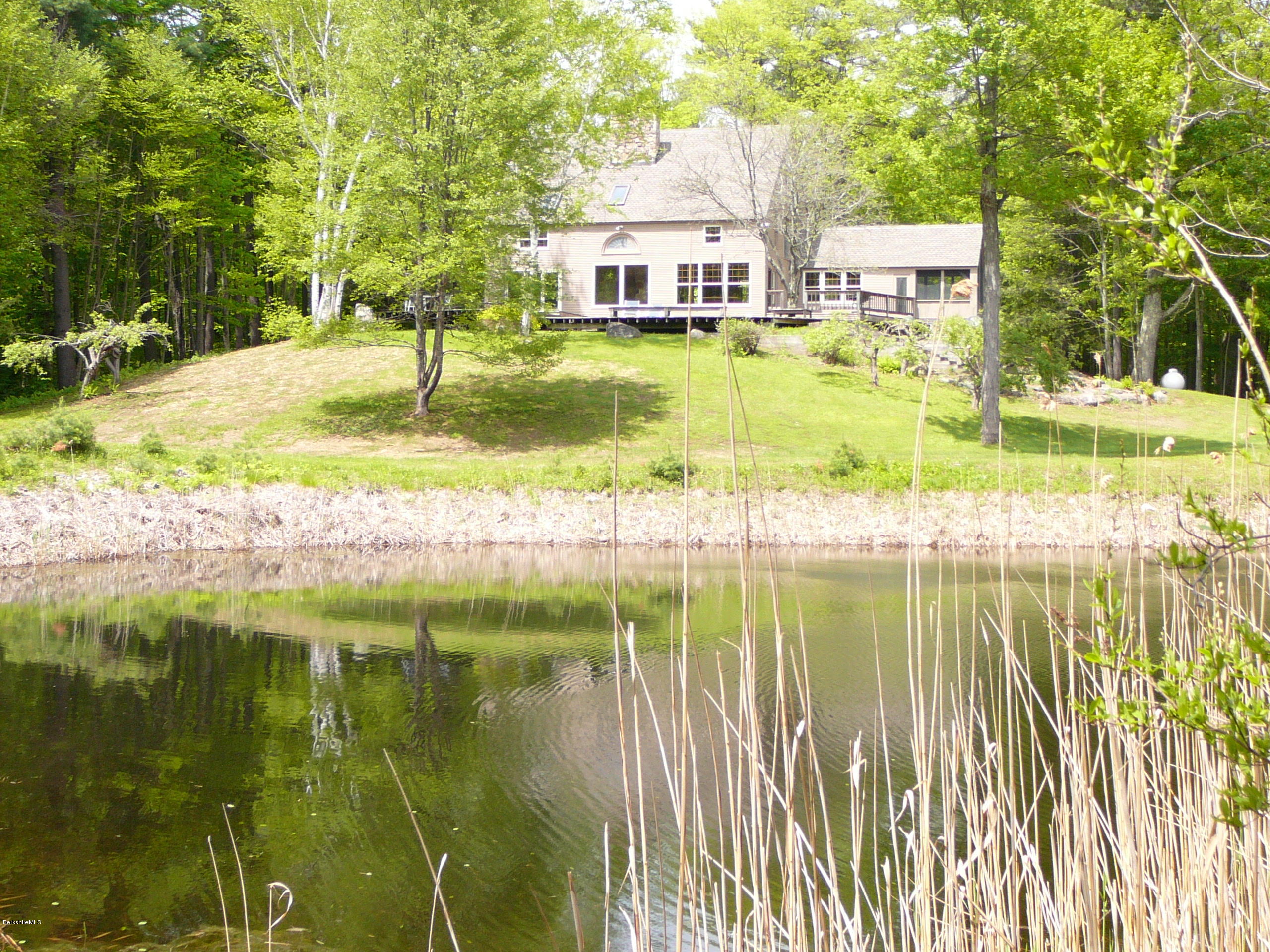 126 Tyringham Road Monterey, MA 01245 - Photo 1 of 35 a swimming pool with some trees in the background