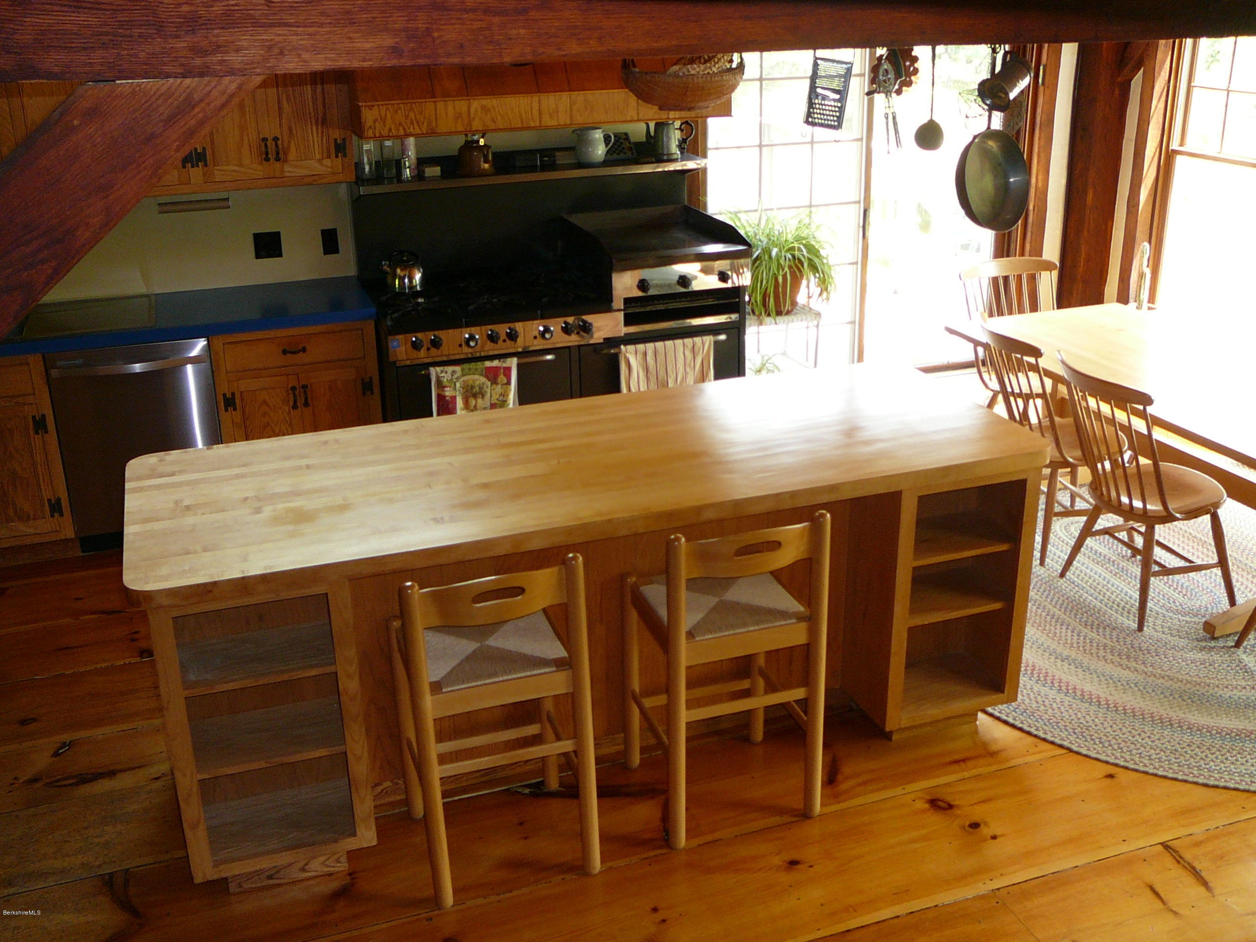 126 Tyringham Road Monterey, MA 01245 - Photo 21 of 35 a kitchen with a table chairs and a stove