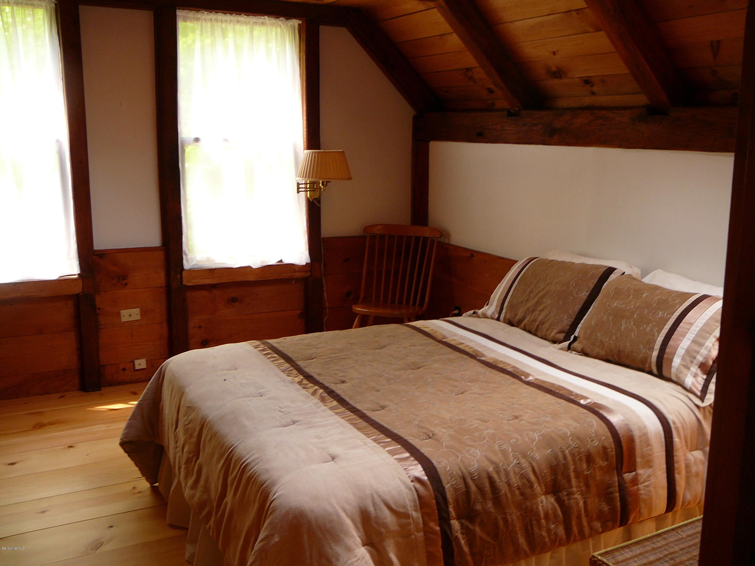 126 Tyringham Road Monterey, MA 01245 - Photo 27 of 35 a bedroom with a bed and wooden floor